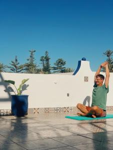 西迪伊夫尼El MOJA SURFHOUSE的坐在垫子上做瑜伽的女人