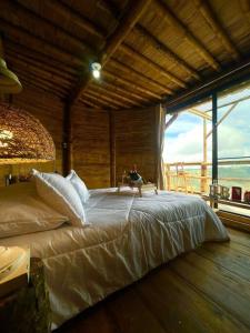 萨兰托HakunaMatata glamping Pumba的一张大床,位于带大窗户的房间里