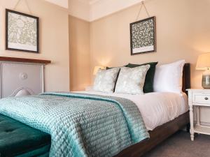 卡迪夫Ty Fry Gardens的一间卧室配有一张带绿毯的床