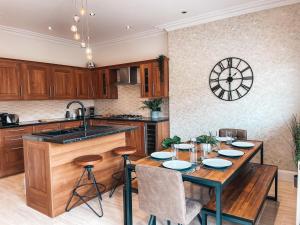 卡迪夫Ty-Fry House, by Solace Stays的厨房配有木桌、椅子和水槽