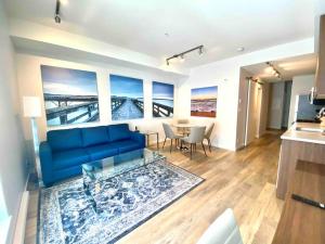 悉尼Perfect Brand New Condo Downtown Sidney的客厅配有蓝色的沙发和桌子