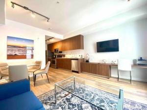 悉尼Perfect Brand New Condo Downtown Sidney的一间带蓝色沙发的客厅和一间厨房