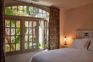 洛杉矶马尔蒙庄园酒店的一间卧室设有一张床和一个大窗户