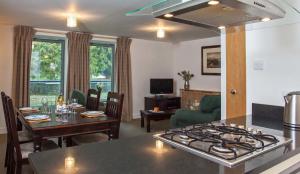 奥古斯都堡Raven Wing Apartments - Highland Club Scotland的厨房以及带炉灶和桌子的客厅。