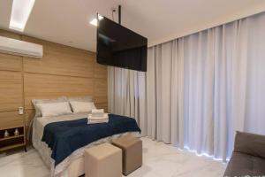 瓜鲁柳斯Lovely Studio - GRU的一间卧室配有一张床和一台平面电视