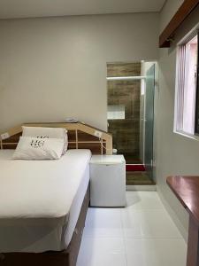 圣保罗卡劳酒店的一间卧室设有一张床和一个步入式淋浴间。