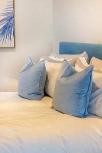 基督城St Albans Gem Single level studio with Queen bed的一张带蓝色和白色枕头的床