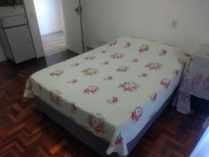 马塞约Quarto em Apto Compartilhado BEIRA MAR的一张床上的白色毯子,上面有鲜花