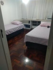 马塞约Quarto em Apto Compartilhado BEIRA MAR的一间卧室设有两张床,铺有木地板