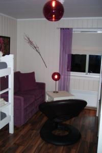 勒罗斯Rørosvidda Hotell的客厅配有紫色沙发和桌子