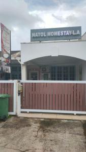 古晋6BR Single Storey Tabuan Jaya By Natol Homestay的前面有木栅栏的建筑