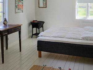 巴斯塔德Holiday home BÅSTAD的一间卧室配有一张床、一张桌子和一张桌子