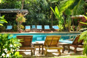 南芭堤雅Rabbit Resort Pattaya的一组椅子坐在游泳池旁