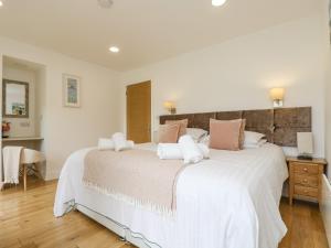 特鲁罗Birch的卧室配有一张带白色床单和粉红色枕头的大床。