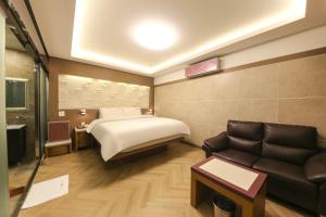 庆州Sugar Hotel的酒店客房,配有床和沙发
