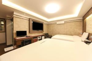 庆州Sugar Hotel的一间卧室配有一张床和一台平面电视