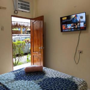 蒙塔尼塔Hostal Tierra y Mar的卧室配有一张床铺,墙上配有电视