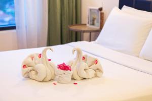 乔治市Tropicana 218 Macalister X Airlevate Suites的床上用毛巾制成的三个天鹅