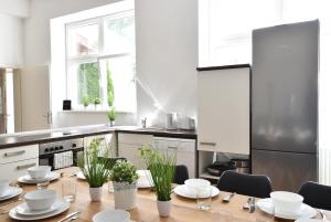 因斯布鲁克Riesiges zentrales Apartment mit Parkplatz的厨房配有木桌、盘子和植物