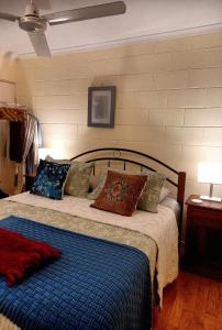 库克敦J & Ella's Holiday House - 2 Bedroom Stays的一间卧室配有一张带蓝色毯子和枕头的床。