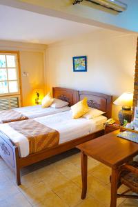棉兰德利河酒店和欧兰达餐厅 的酒店客房设有两张床和一张桌子。