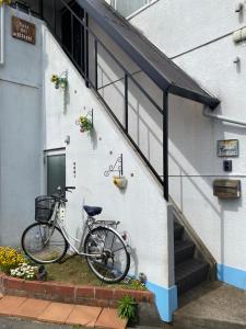 守口Casa del girasolカサデルヒラソル的停在有楼梯的建筑旁边的自行车