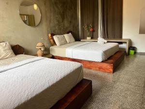 圣萨尔瓦多La Zona Hostel的配有镜子的酒店客房内的两张床