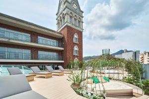 长崎ROYAL CHESTER NAGASAKI hotel&retreat的一座带躺椅钟楼建筑