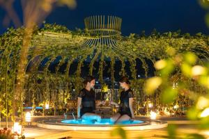 长崎ROYAL CHESTER NAGASAKI hotel&retreat的两个女人晚上坐在喷泉里