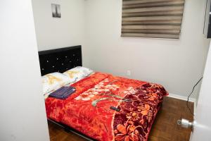 布兰普顿Nathan’s Place的一间卧室配有一张带红色毯子的床