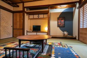 佐贺市Tsukasa Ryokan的客厅配有桌子和地毯。