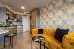 弗罗茨瓦夫Starter 24 Wrocław - MAMY WOLNE POKOJE !的一间带黄色沙发的客厅和一间厨房