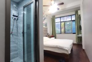 海口海口巴纳纳国际青年旅舍的一间卧室设有一张床和一个玻璃淋浴间