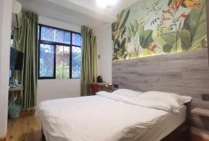 海口海口巴纳纳国际青年旅舍的卧室设有白色的床和大窗户