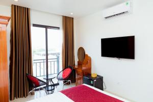 河内Vĩnh Sơn Nội Bài的一间卧室配有一张床和一台平面电视