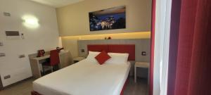 斯培西亚Eden Rooms的卧室配有白色床和红色床头板