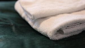 舍夫德RS Lägenhetshotell Skövde的绿床上的一堆白色毛巾