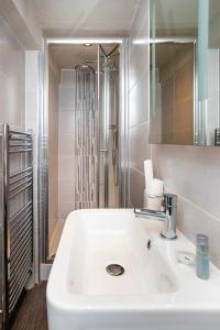 斯基普顿长毛羊宾馆的浴室配有白色水槽和淋浴。