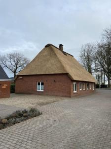 KrempdorfFerienwohnung Schipmann的茅草屋顶的大型砖砌建筑