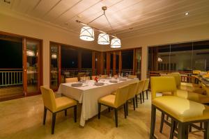 马埃岛Villa Salazie的一间带长桌和黄色椅子的用餐室