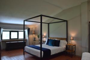 基安奇安诺泰尔梅Casa M Vineyard的一间卧室配有一张带蓝色枕头的天蓬床