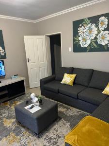 姆巴巴内GoldenWays Apartments的客厅配有沙发和桌子