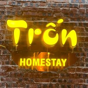 高平Trốn Homestay, Cao Bằng的砖墙上的 ⁇ 虹灯标志,上面写着“咖啡馆的 ⁇ 人造”