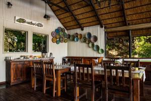 PungaIchingo Chobe River Lodge by Mantis的用餐室设有木桌、椅子和窗户。