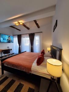锡纳亚Casa Larisa Antonia Apartment的一间卧室配有一张带红色枕头的大床