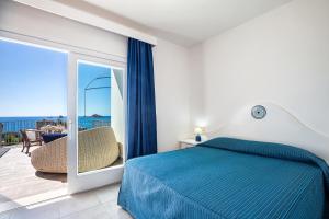 圣玛丽亚纳瓦雷阿古利亚斯特拉酒店的一间卧室设有蓝色的床和一个阳台