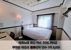 仁川市仁川富平丰子酒店的一间卧室配有一张床、一张书桌和一个窗户。
