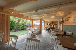 朴次茅斯佛罗伦萨花园精品酒店及餐厅的餐厅拥有木墙和桌椅