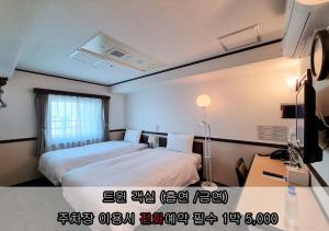 仁川市仁川富平丰子酒店的酒店客房设有两张床和窗户。