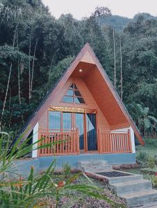 贝都古Popitan Garden Campground & Glamping Bedugul的一个小房子,设有大窗户和甲板